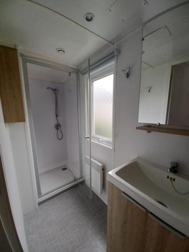 乌尔加特Mobil home équipé camping 5*的带淋浴和盥洗盆的白色浴室