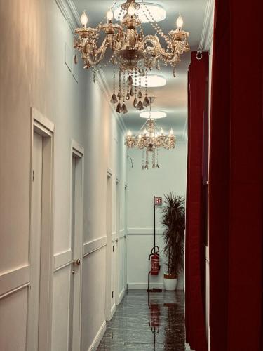 罗马Rosa Italia Hotel Roma的走廊上设有吊灯,走廊上设有地板