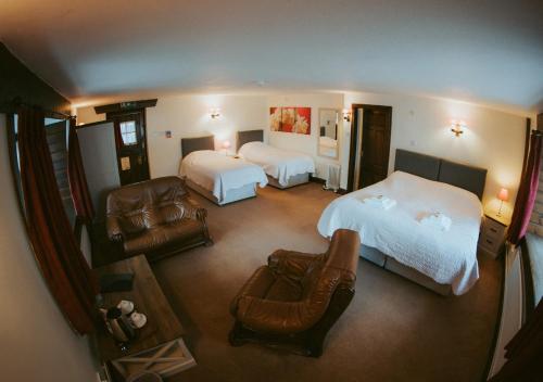 霍尼顿希斯菲尔德旅馆的大型酒店客房,配有两张床和椅子