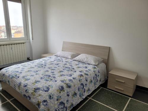 卡萨莱蒙费拉托Tra Milano, Torino e Genova的一间卧室配有一张带蓝色花卉棉被的床