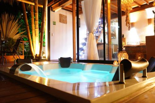 瓜塔佩Ibuku Hotel Guatapé - Chalets的一个带椅子和桌子的房间的热水浴缸