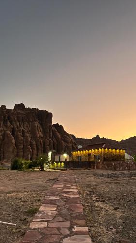 Mogayraمزرعة القمة的沙漠中的一座建筑,背景是一座山