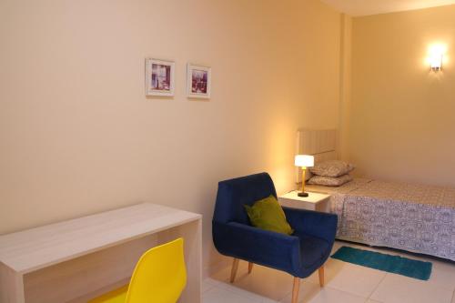 Fernando de la MoraDe la Mora Hostal的一间卧室配有蓝色椅子和一张床