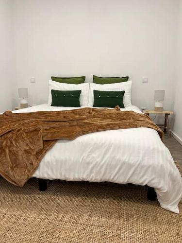 托朗Casa da Xica的一间卧室配有一张带绿色和白色枕头的大床