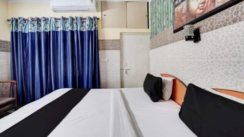 阿格拉Pyrenees Homestay的一间卧室配有一张蓝色窗帘的床
