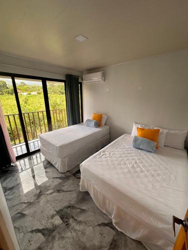 福尔图纳Luxury Villas Arenal的带阳台的客房内的两张床