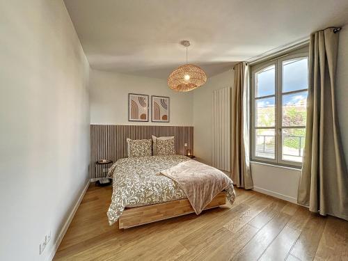 特鲁瓦Le Patio’nnement, Troyes, Centre的一间卧室设有一张床和一个大窗户