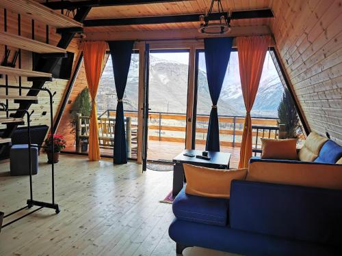 卡兹贝吉Arsha View的客厅设有蓝色的沙发和大窗户