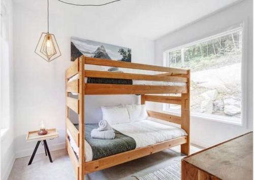 La ConceptionModern Chalet, 10 mins from Tremblant Ski Resort的一间卧室配有双层床和窗户。