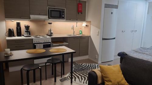 拉彭兰塔Moderni ja supermukava asunto! 65'Smart TV, Valokuitunetti, lähellä yliopistoa!的一个带桌子和台面的小厨房