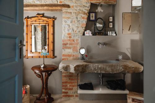 希尼奥Tenuta Bricchi的一间带石制水槽和镜子的浴室