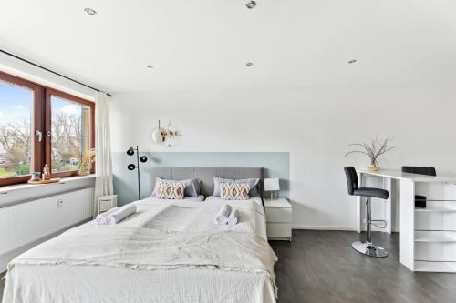拜罗伊特Salí Homes HZ42 Studio im Zentrum Bayreuths mit Balkon的白色卧室配有一张大床和一张书桌