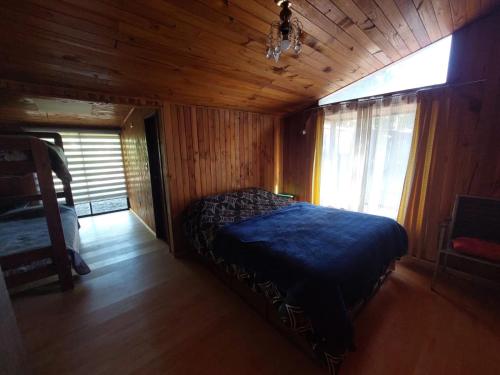 普孔Grandes cabañas的木制客房内的一间卧室,配有一张床