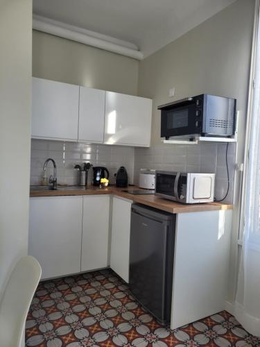 索米耶尔Studio Sommieres的小厨房配有白色橱柜和微波炉
