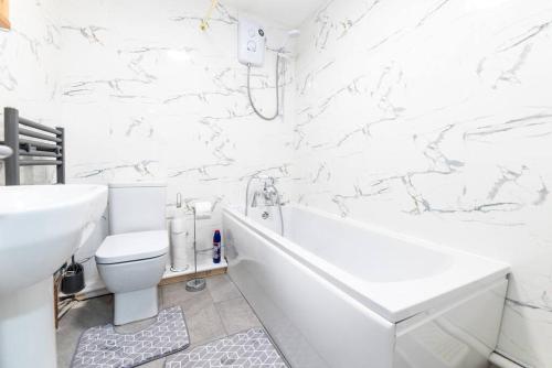 诺丁汉Holiday Lodge, close to Nottingham City Centre的白色的浴室设有浴缸、卫生间和水槽。