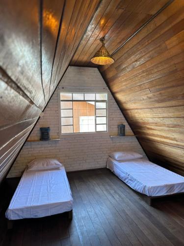 贝卢港Chale Bombinhas/Borto Belo的阁楼间 - 带两张床和窗户