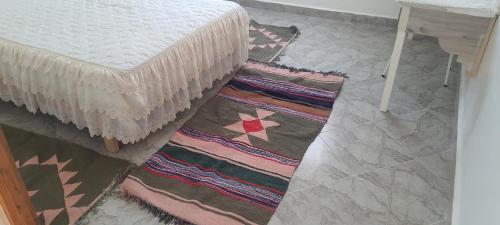 苏塞Dar souade chatt mariem的一间位于床边的地板上,有两块地毯的房间