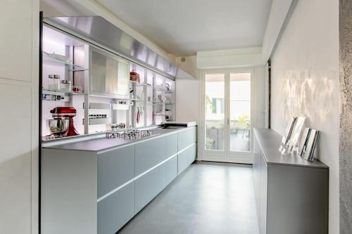 佩萨罗luxury apartment的大型厨房配有白色橱柜和大窗户