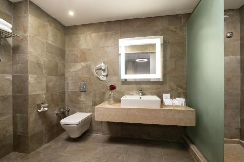 十月六日城Dhara Residence E2 Lodge Hotel的一间带水槽、卫生间和镜子的浴室