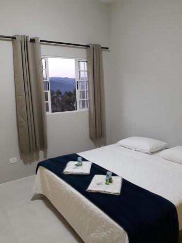 迈里波朗Pousada TOP的一间卧室配有两张床、毛巾和窗户