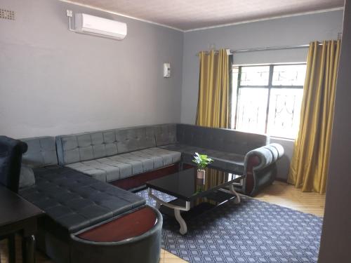 利文斯顿Ramachi apartments的客厅配有沙发和桌子