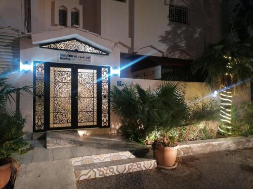 麦地那Khair Jewaar Apartments Al Madinah的夜晚有灯的房子的前门