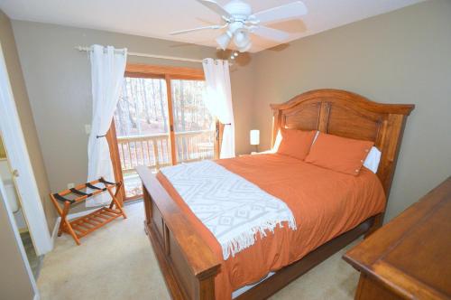 Morton GroveThe Fern - Woodland Escape的一间卧室配有一张带吊扇和窗户的床。
