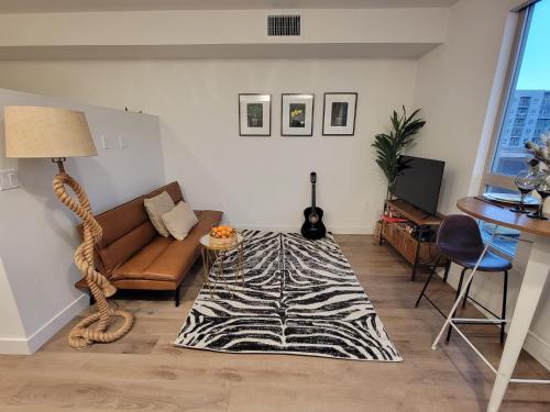 圣地亚哥Amazing big studio near Balboa Park Jacuzzi rooftop free parking!的客厅的地板上铺有斑马地毯。