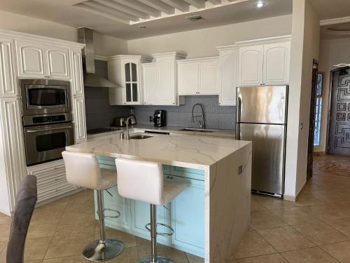 佩尼亚斯科港Sonoran Sky Resort Vista a Playa Azul的厨房配有白色橱柜和不锈钢冰箱