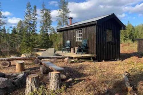 孔斯温厄尔Velkommen til Finnskogen og minihytta Rimbila的小屋外设有野餐桌和椅子