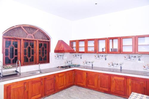 希克杜沃hikka T&O nature villa的厨房配有木制橱柜、水槽和窗户。