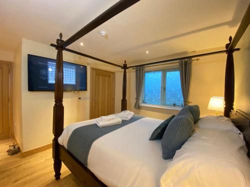 蒂贝Lune Cottage nestled between Lake District and Yorkshire Dales的卧室配有一张大床,墙上配有电视