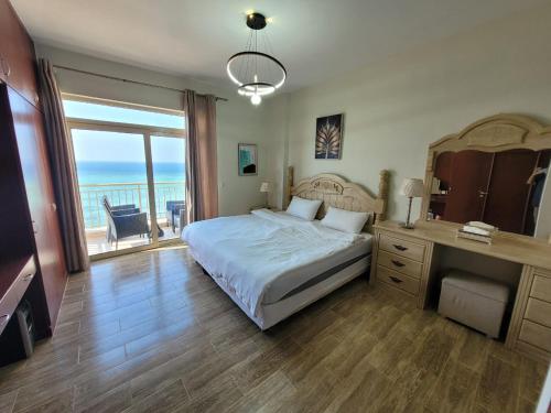 阿卜杜勒国王经济城Royal Beach Apartment的一间卧室配有一张床,享有海景