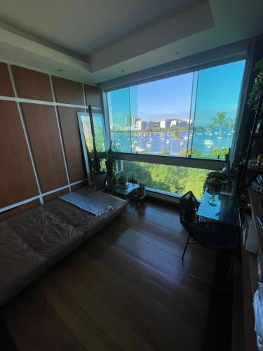 里约热内卢Apartamento Urca的一间房间,前方设有一张沙发,窗户前方设有一张沙发