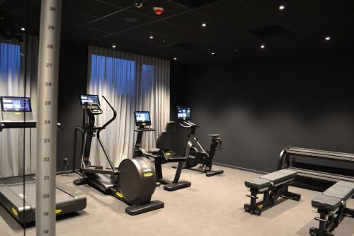维佐拉提契诺TRIBE Milano Malpensa的一间健身房,里面设有数个健身器材