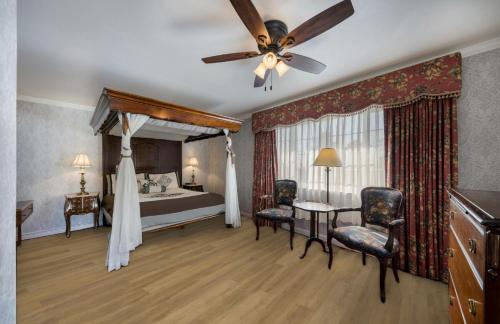 卡梅尔卡梅尔旅馆及套房的一间卧室配有一张床和吊扇