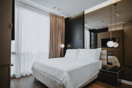那不勒斯POETICA BOUTIQUE SKY HOTEL的卧室设有一张白色大床和一扇窗户。