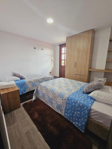 菲兰迪亚Apartamento en Filandia的一间卧室设有两张床和窗户。
