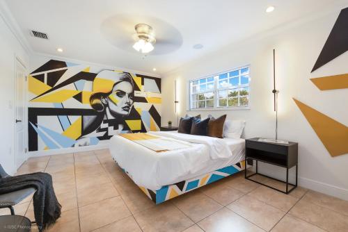 迈阿密Le Femme Paradise的卧室配有一张大床,墙上挂有绘画作品