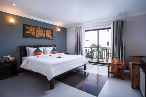 暹粒Ratana Angkor Hotel的一间卧室设有一张大床和一个大窗户