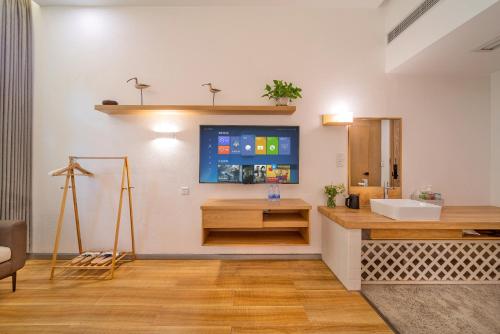 重庆无隅酒店(重庆缙云山西南大学店)的一间带水槽的浴室和墙上的电视