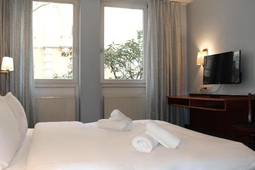 波恩Hotel Mozart Bonn的酒店客房,配有带毛巾的床