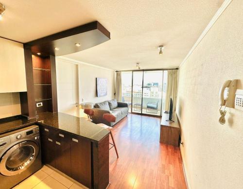 圣地亚哥Arauco Premium Suite的厨房以及带洗衣机和烘干机的客厅。