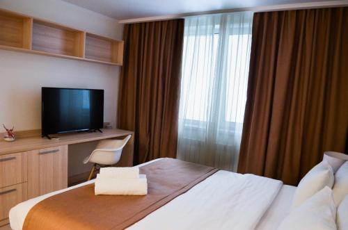 阿斯塔纳Yes Апарт-отель的配有一张床和一台平面电视的酒店客房