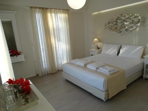 纳克索乔拉Anassa Suites的白色卧室配有一张带白色枕头的大床