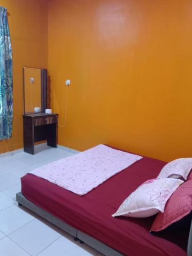 巴佐Pelangi Homestay 2的橙色墙壁间的一张床位