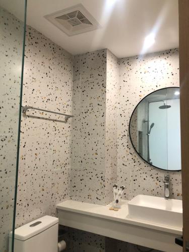 邦劳Fun Hotel的浴室设有镜子、盥洗盆和卫生间