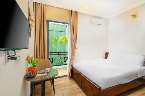 岘港Nguyên Hương Hotel的一间卧室设有一张床、一个窗口和一张桌子