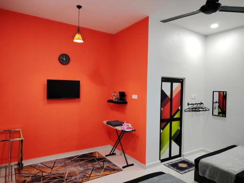 瓜拉丁加奴Roomstay Kak Ton的客厅设有橙色墙壁和电视