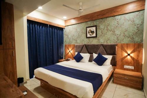 艾哈迈达巴德Hotel Mahaveer的一间卧室配有一张带蓝色枕头的大床